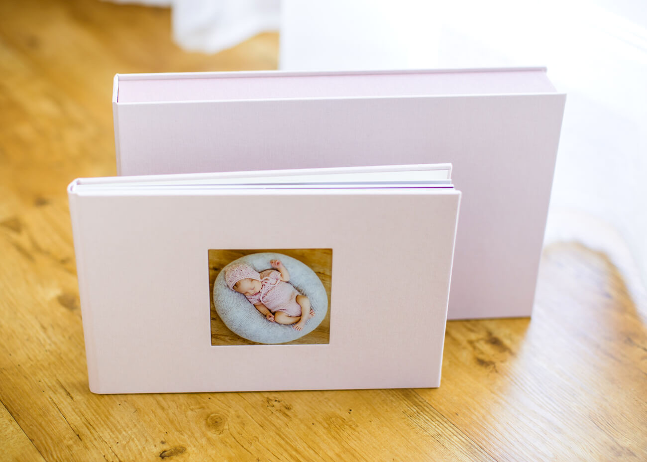 rosa farbenes Fotoalbum mit Box dahinter