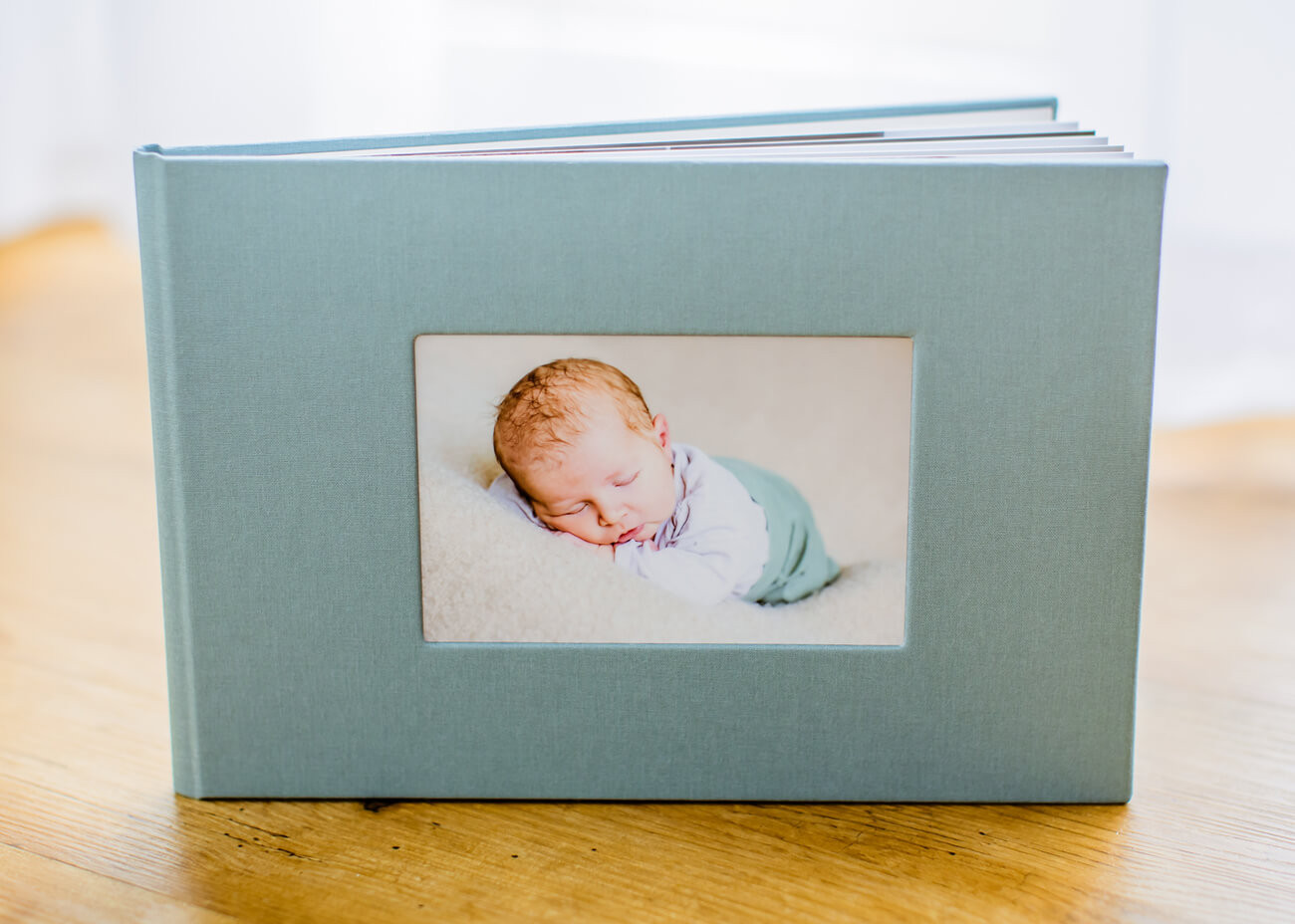 aufgefächertes, grünes Babyfotoalbum