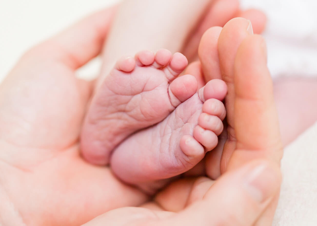 Babyfüßchen werden von Händen gehalten, Neugeborenenfotoshooting Erzgebirge
