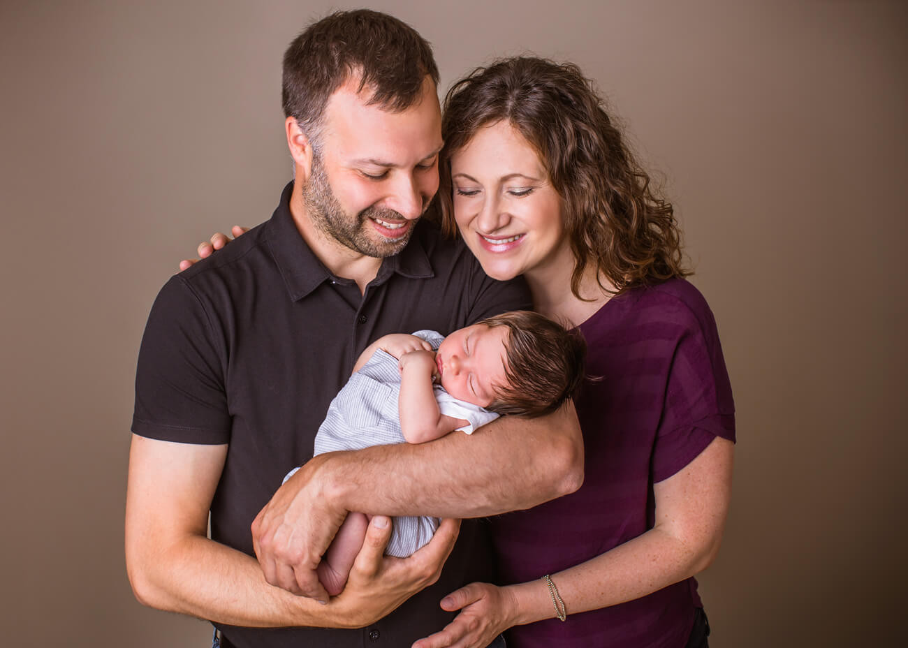 Eltern bestaunen ihr Baby im Arm