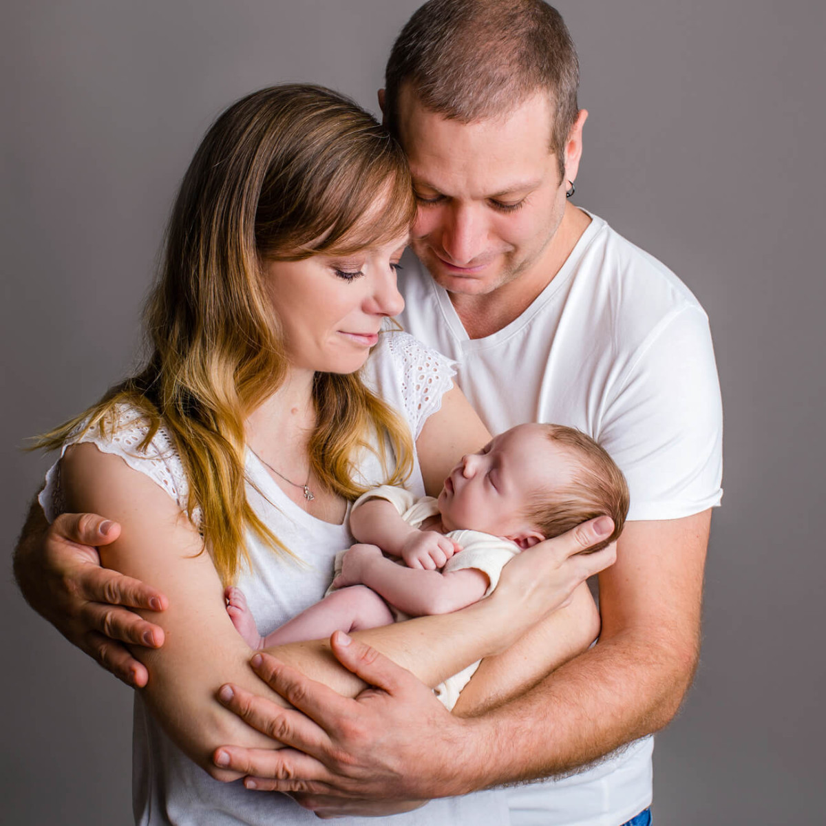 Eltern halten Baby im Arm