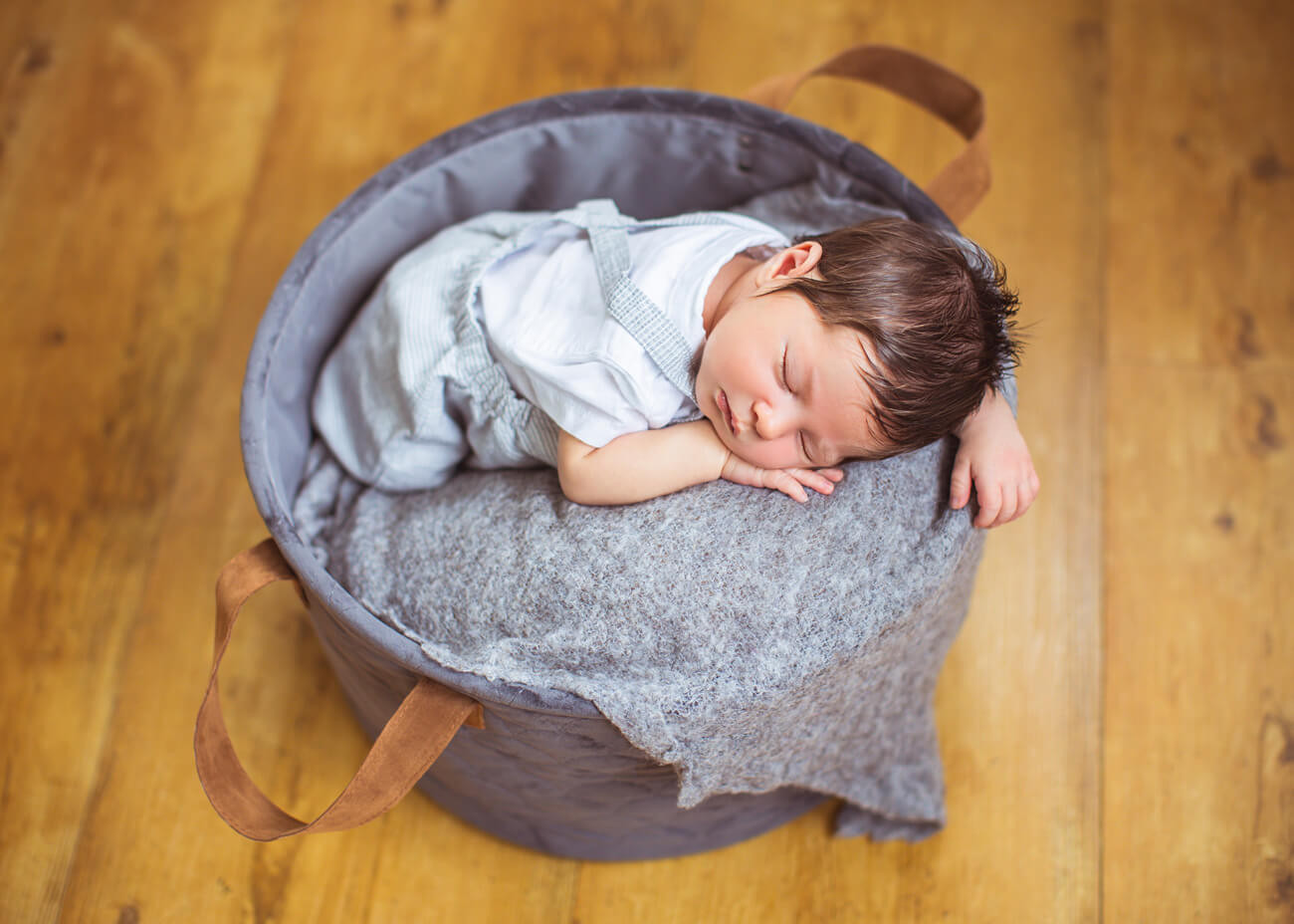 Baby schläft im Stoffkörbchen von oben