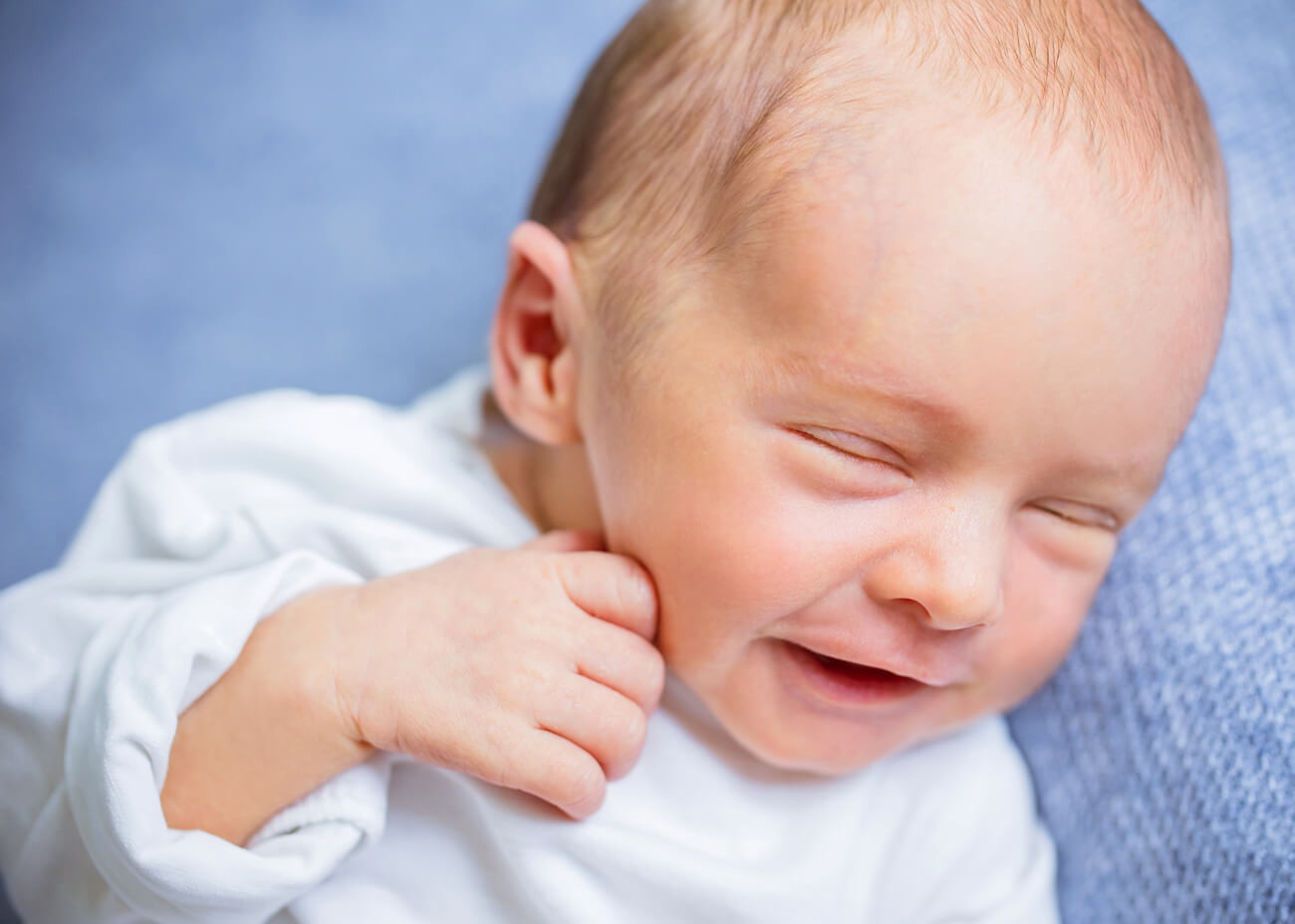 lachendes Baby mit Hand am Mund, Babyfotografin Pockau